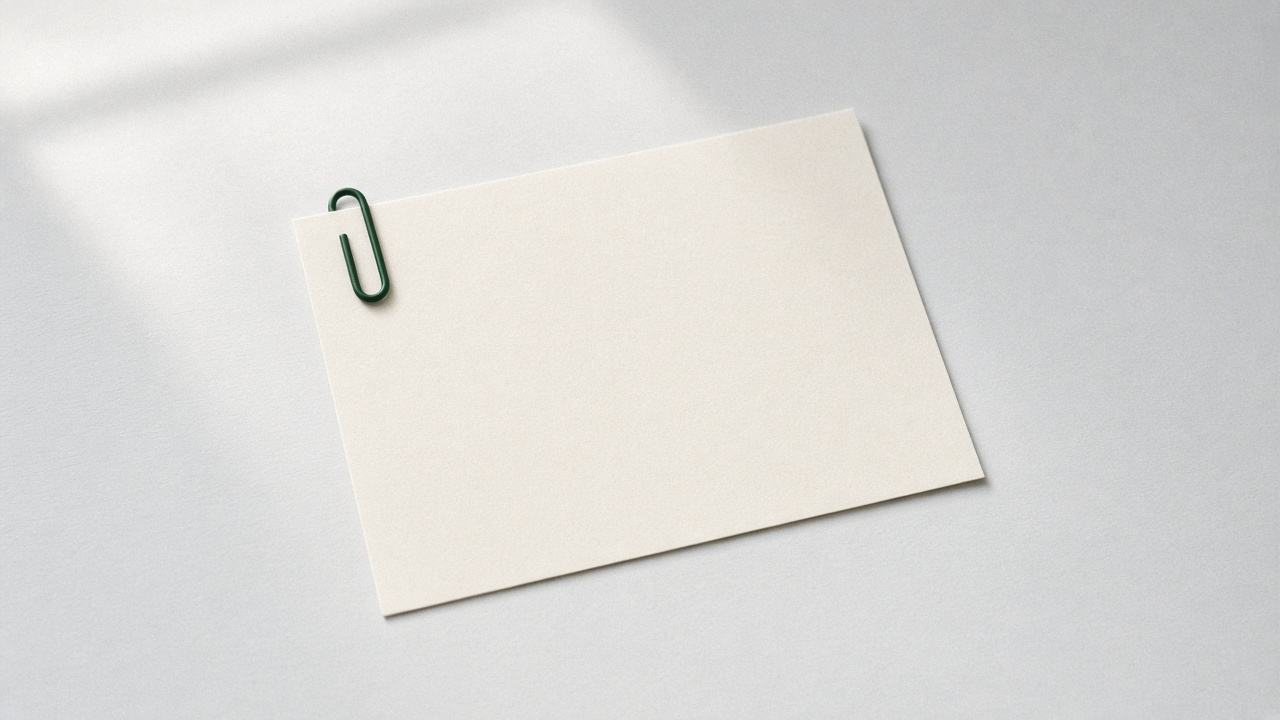 A blank page held by a green paperclip